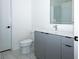 Bathroom featuring gray cabinets, white tile flooring, and a glass shower at 788 W Marietta Nw St # 311, Atlanta, GA 30318