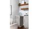 Chic bar area with gray cabinets, white countertops, floating wooden shelves, and glass stemware racks at 1364 Westboro Sw Dr, Atlanta, GA 30310