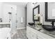 Modern bathroom with double bowl sinks, walk-in shower with patterned tile, and mosaic tile floors at 1364 Westboro Sw Dr, Atlanta, GA 30310