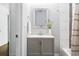Stylish bathroom with gray vanity, modern fixtures, decorative mirror, and tiled shower with a shower curtain at 1364 Westboro Sw Dr, Atlanta, GA 30310