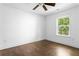 Cozy bedroom with hardwood floors, ceiling fan, and bright natural light from a window overlooking the backyard at 1364 Westboro Sw Dr, Atlanta, GA 30310