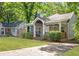 Inviting home with a rocking chair porch, lush lawn, and shaded driveway at 1364 Westboro Sw Dr, Atlanta, GA 30310