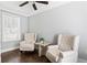 Cozy sitting room with hardwood floors, a ceiling fan, two tufted chairs and a center table at 1364 Westboro Sw Dr, Atlanta, GA 30310