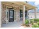 Inviting front porch with brick columns and charming seating area with plants at 171 Osier Dr, Mcdonough, GA 30252
