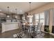 Kitchen nook and island featuring stainless steel appliances, wood flooring, granite countertops, and designer lighting at 171 Osier Dr, Mcdonough, GA 30252
