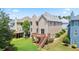 Exterior view of the home featuring a deck and well-maintained lawn and lush trees at 180 Mirramont Lake Dr, Woodstock, GA 30189
