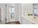 All-white bathroom with double sink, shower, toilet, and a plant for natural decor at 180 Mirramont Lake Dr, Woodstock, GA 30189