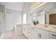 Bright bathroom featuring double vanity, large mirror, tub, and tiled floors at 180 Mirramont Lake Dr, Woodstock, GA 30189