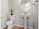 Half bathroom with pedestal sink, round mirror, and modern fixtures at 180 Mirramont Lake Dr, Woodstock, GA 30189