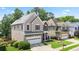 Two-story home with well-kept lawn, two-car garage, and inviting front porch at 180 Mirramont Lake Dr, Woodstock, GA 30189