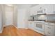 Bright kitchen features wooden floors, white cabinets and appliances at 180 Mirramont Lake Dr, Woodstock, GA 30189