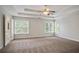 Large main bedroom with tray ceiling, cozy carpet, and bright windows that let in natural light at 180 Mirramont Lake Dr, Woodstock, GA 30189