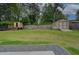 Expansive backyard featuring a playhouse, storage shed, ample green space, and wooden perimeter fence at 2324 Ithica Se Dr, Marietta, GA 30067