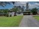 Photo shows an updated two-story white brick house with a red door and a covered parking area at 2324 Ithica Se Dr, Marietta, GA 30067