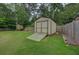 Backyard storage shed with ramp access, surrounded by a lush green lawn and mature trees at 2324 Ithica Se Dr, Marietta, GA 30067