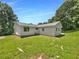 View of the home's backyard with green grass and simple white exterior at 2492 Wild Rose Cir, Lawrenceville, GA 30044