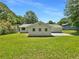 View of the home's backyard with green grass and simple white exterior at 2492 Wild Rose Cir, Lawrenceville, GA 30044