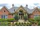 Elegant clubhouse exterior with brick facade, arched entrance, and manicured landscaping at 1535 Duluth Hwy # 1101, Lawrenceville, GA 30043