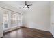 Bright bedroom featuring wood floors, ceiling fan, large window, and neutral paint at 4855 Payson Se Ter # 3, Atlanta, GA 30339
