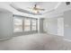 Bedroom featuring tray ceiling, fan, three windows and neutral carpet at 4855 Payson Se Ter # 3, Atlanta, GA 30339