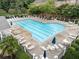 Community pool with lounge chairs, umbrellas, and manicured landscaping around it at 4855 Payson Se Ter # 3, Atlanta, GA 30339