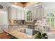 Well-appointed kitchen features custom cabinetry, granite countertops, and a sunny window view at 789 Rutland Ct, Lithonia, GA 30058