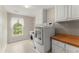 Laundry room with a front load washer, dryer, and lots of cabinets for storage and organizing at 789 Rutland Ct, Lithonia, GA 30058