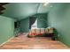 A green bedroom featuring hardwood floors, a TV, and a simple bed setup at 1033 Justice Nw Ln, Acworth, GA 30102
