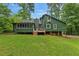 View of the backyard with green siding, wooden deck and lots of lawn at 1033 Justice Nw Ln, Acworth, GA 30102