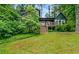 Charming two-story home with a wooden deck and stairs, surrounded by lush green landscaping at 1033 Justice Nw Ln, Acworth, GA 30102