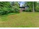 Green home with large front lawn, wooden deck, and beautiful surrounding greenery at 1033 Justice Nw Ln, Acworth, GA 30102