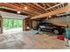 The garage features exposed ceiling beams, storage shelves, and a parked car at 1033 Justice Nw Ln, Acworth, GA 30102