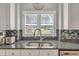 Kitchen detail showcasing stainless steel sink, granite countertops, and mosaic tile backsplash at 2190 Stephen Long Ne Dr, Atlanta, GA 30305