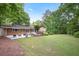 Expansive backyard with a brick home, large grassy area, patio and a deck with seating at 225 River Springs Dr, Sandy Springs, GA 30328