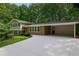 Charming exterior elevation with a brick facade, carport, and a well-manicured lawn with mature trees at 225 River Springs Dr, Sandy Springs, GA 30328