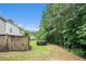 Secluded backyard featuring lawn, privacy fence, and mature trees at 129 Finsbury Ln, Woodstock, GA 30188