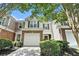 Inviting two-story townhouse featuring a stone and siding facade, attached garage, and charming curb appeal at 129 Finsbury Ln, Woodstock, GA 30188