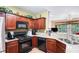 Well-lit kitchen featuring granite countertops, dark wood cabinets, and stainless steel appliances at 129 Finsbury Ln, Woodstock, GA 30188