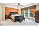 A lovely main bedroom featuring a ceiling fan, large window, bedside tables, and a bench at 129 Finsbury Ln, Woodstock, GA 30188
