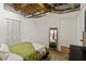 A cozy bedroom featuring exposed duct work, a white closet, and a green bedspread at 19 Hilliard Se St # 13, Atlanta, GA 30312