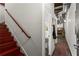 Hallway with red-stained staircase leading to a door with access to a bathroom and living area at 19 Hilliard Se St # 13, Atlanta, GA 30312
