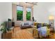 Relaxing living room with hardwood floors, comfortable seating, and views of lush greenery through expansive windows at 19 Hilliard Se St # 13, Atlanta, GA 30312
