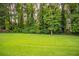 Expansive backyard featuring a lush green lawn and mature trees at 214 Jamestown Ave, Jonesboro, GA 30236