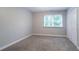 A simple bedroom features neutral paint, carpet, one window, and a closet at 214 Jamestown Ave, Jonesboro, GA 30236