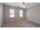A simple bedroom features neutral paint, carpet, and two windows at 214 Jamestown Ave, Jonesboro, GA 30236