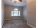 Bright bedroom with a unique arch window for natural light, and neutral walls and carpet at 214 Jamestown Ave, Jonesboro, GA 30236