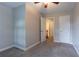 The carpeted bedroom offers neutral decor with an open door leading to the stairway landing at 214 Jamestown Ave, Jonesboro, GA 30236