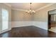 Dining room features hardwood floors, paneled walls, large windows and modern chandelier lighting at 214 Jamestown Ave, Jonesboro, GA 30236