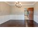 Formal dining room features hardwood floors, paneled walls, and modern chandelier lighting at 214 Jamestown Ave, Jonesboro, GA 30236