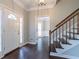Inviting foyer featuring a wood floor, staircase, and glass-paneled front door at 214 Jamestown Ave, Jonesboro, GA 30236